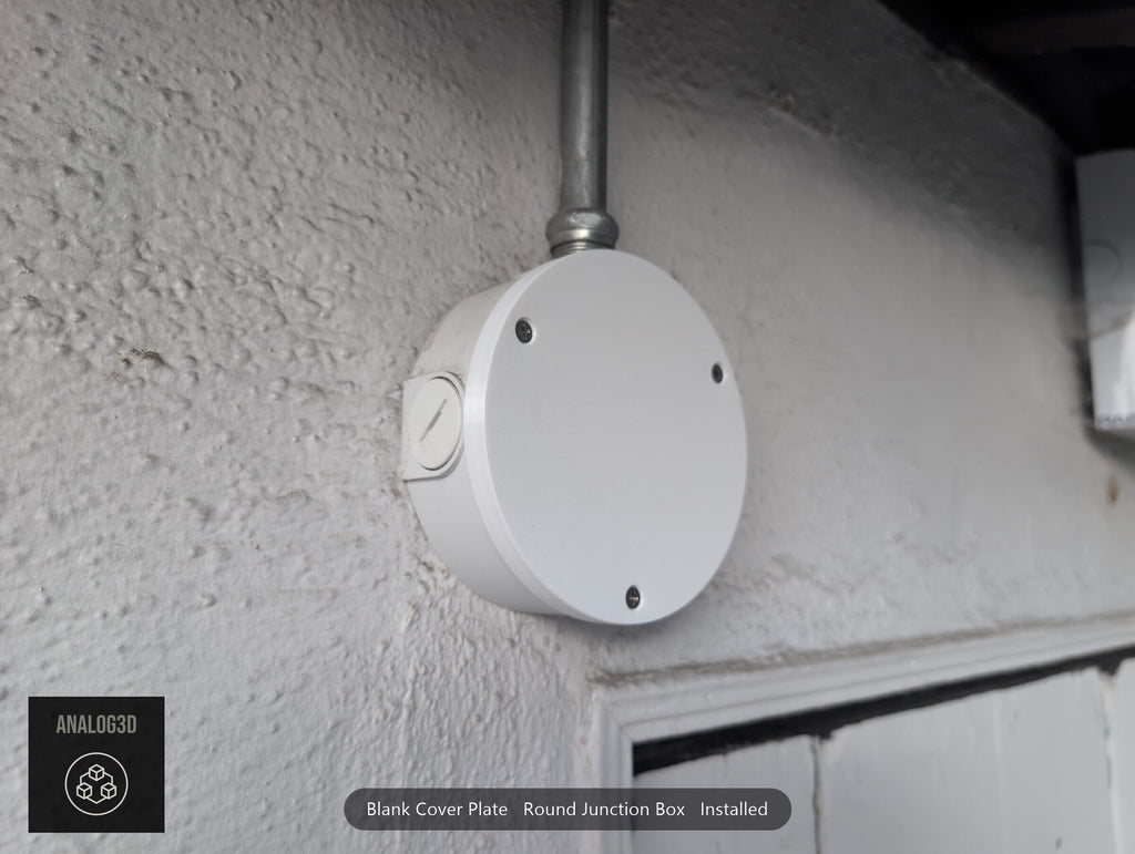Blank cover plate installed on a round junction box, angled view (customer install photo)