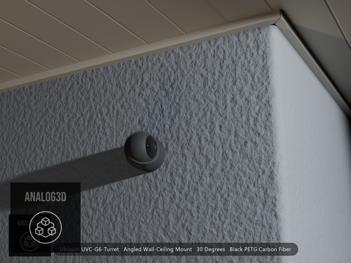 Ubiquiti UVC-G6-Turret angled wall mount in black PETG carbon fiber on a stucco wall at night