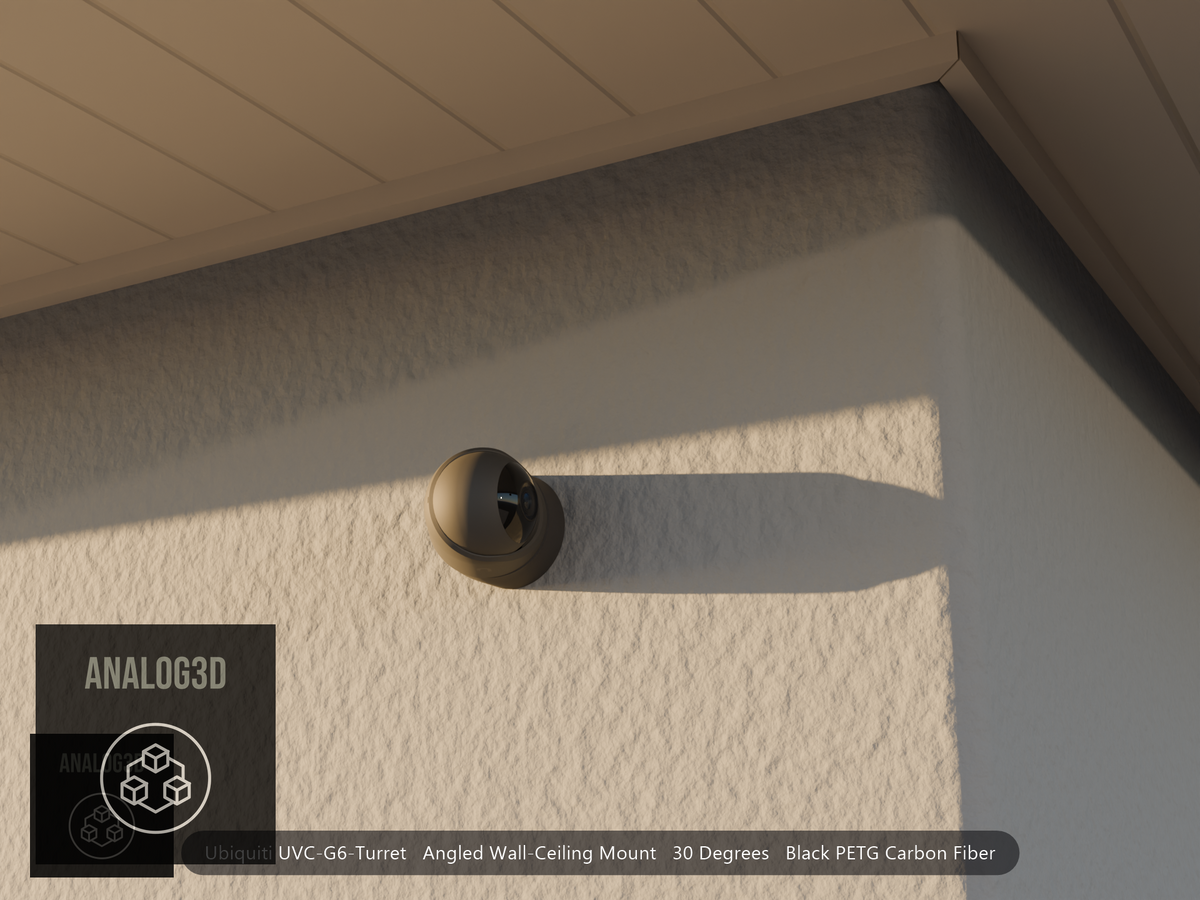 Ubiquiti UVC-G6-Turret angled wall mount in black PETG carbon fiber on a stucco wall at golden hour