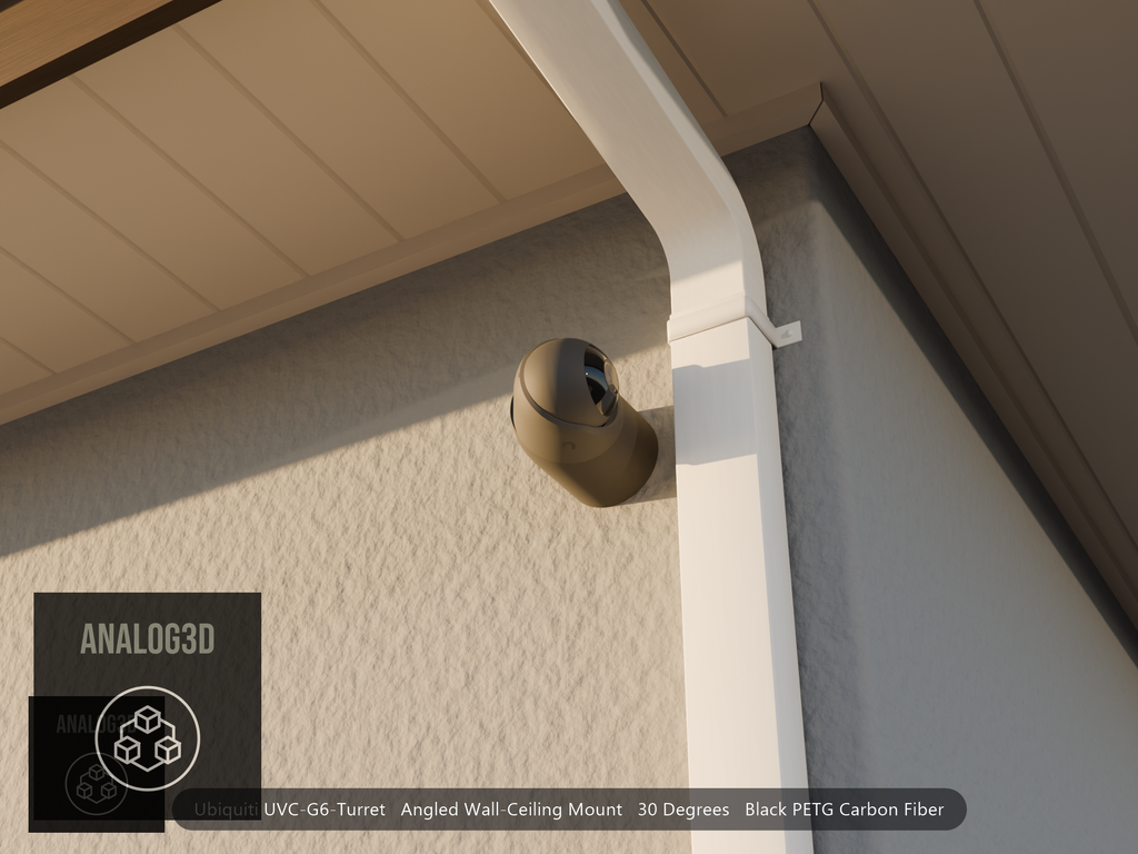 Ubiquiti UVC-G6-Turret on black PETG carbon fiber angled wall mount extending past a downspout on a stucco wall at golden hour