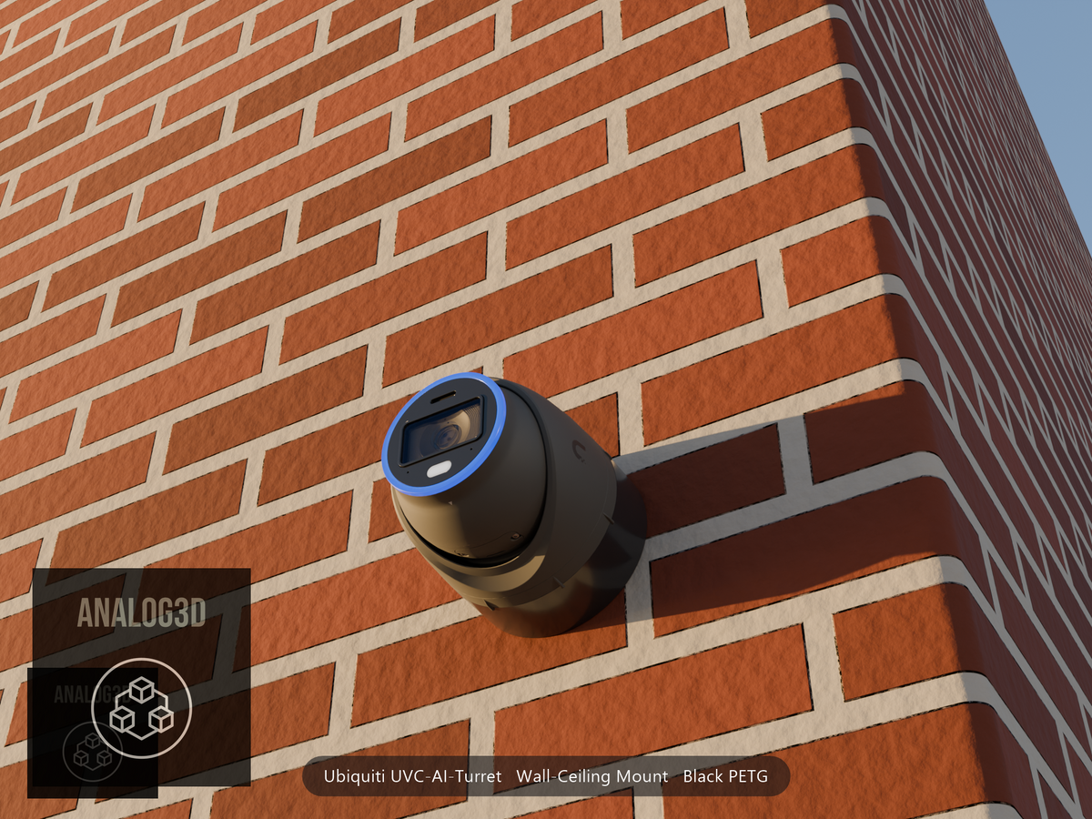 Ubiquiti UVC-AI-Turret on black PETG wall-ceiling mount on a brick wall at golden hour