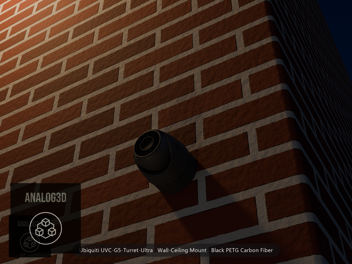 Ubiquiti UVC-G5-Turret-Ultra on black PETG carbon fiber wall-ceiling mount on a brick wall at night