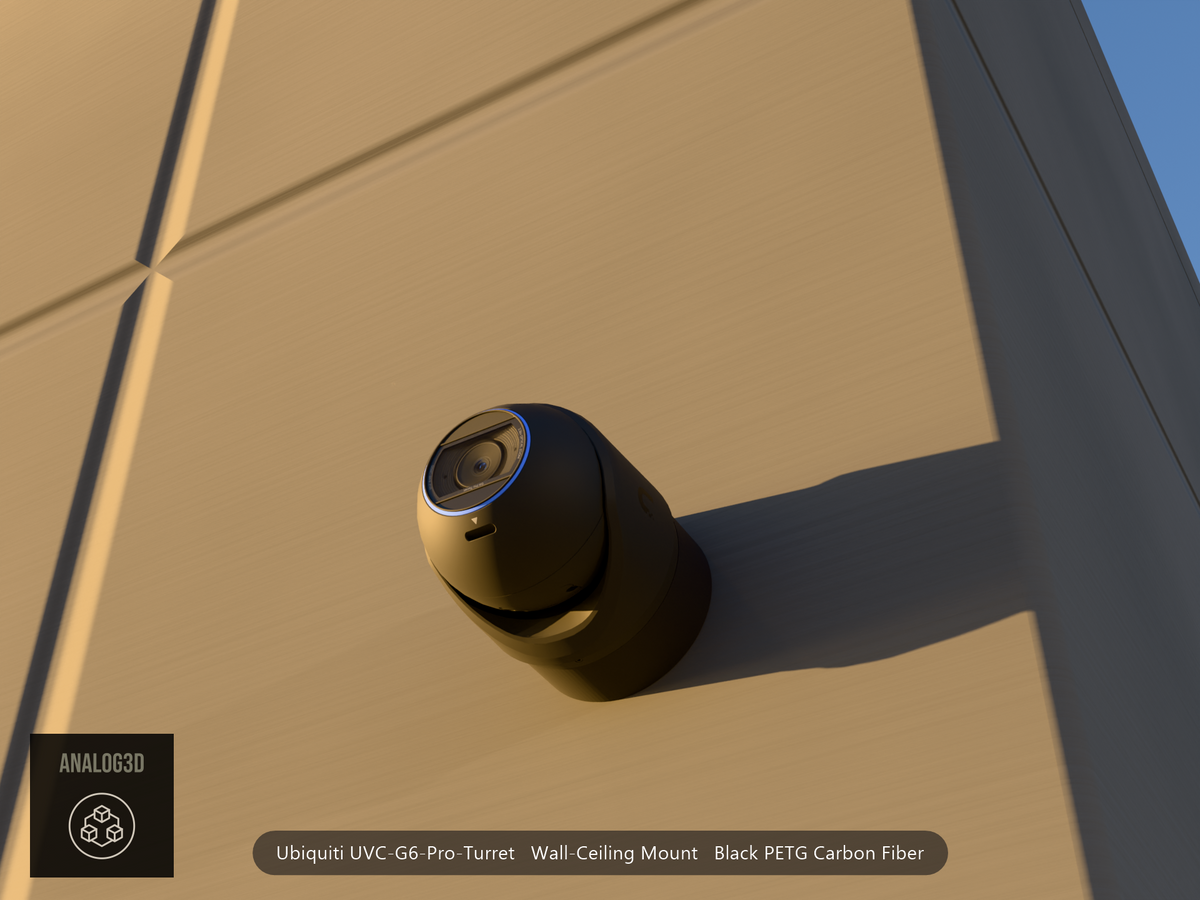 Ubiquiti UVC-G6-Pro-Turret black edition on black PETG carbon fiber wall-ceiling mount on a concrete wall at golden hour