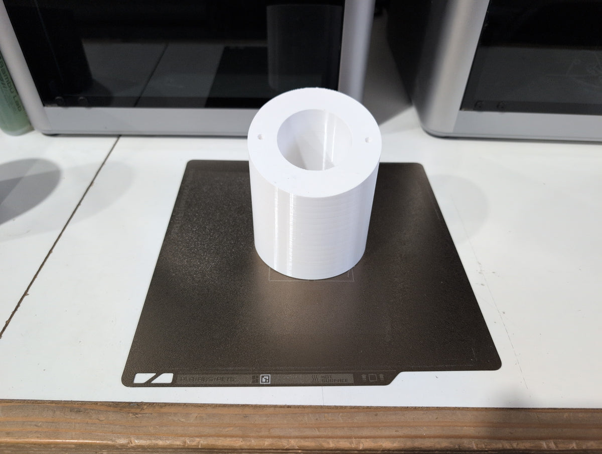 Unedited photo: UniFi angled soffit mount body, white PETG, fresh off the print bed (same body across the UniFi soffit family)